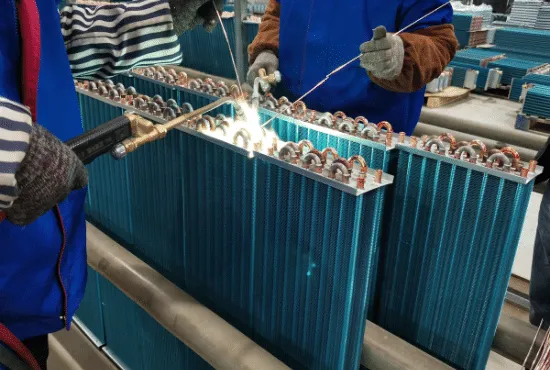 Technicians welding a finned heat exchanger for an industrial chiller